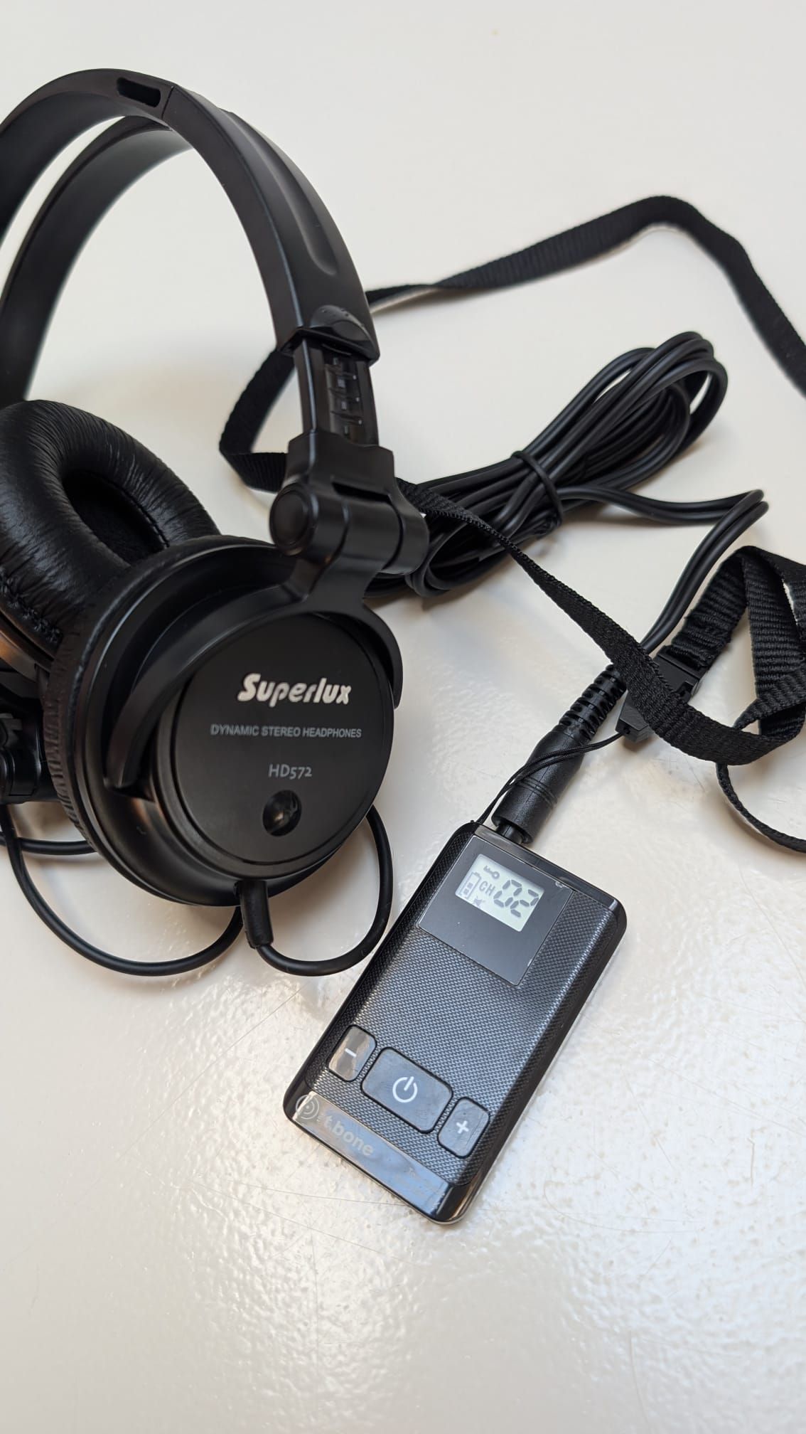 Black Sony headset with a wired control box on a light surface.