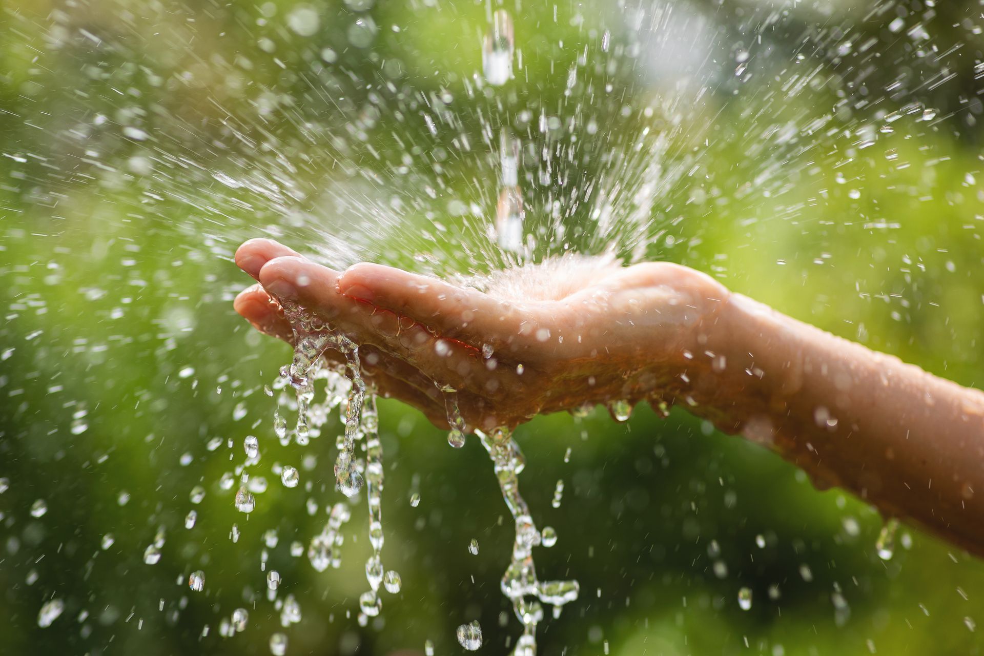 Woman's wet hands with water splashing