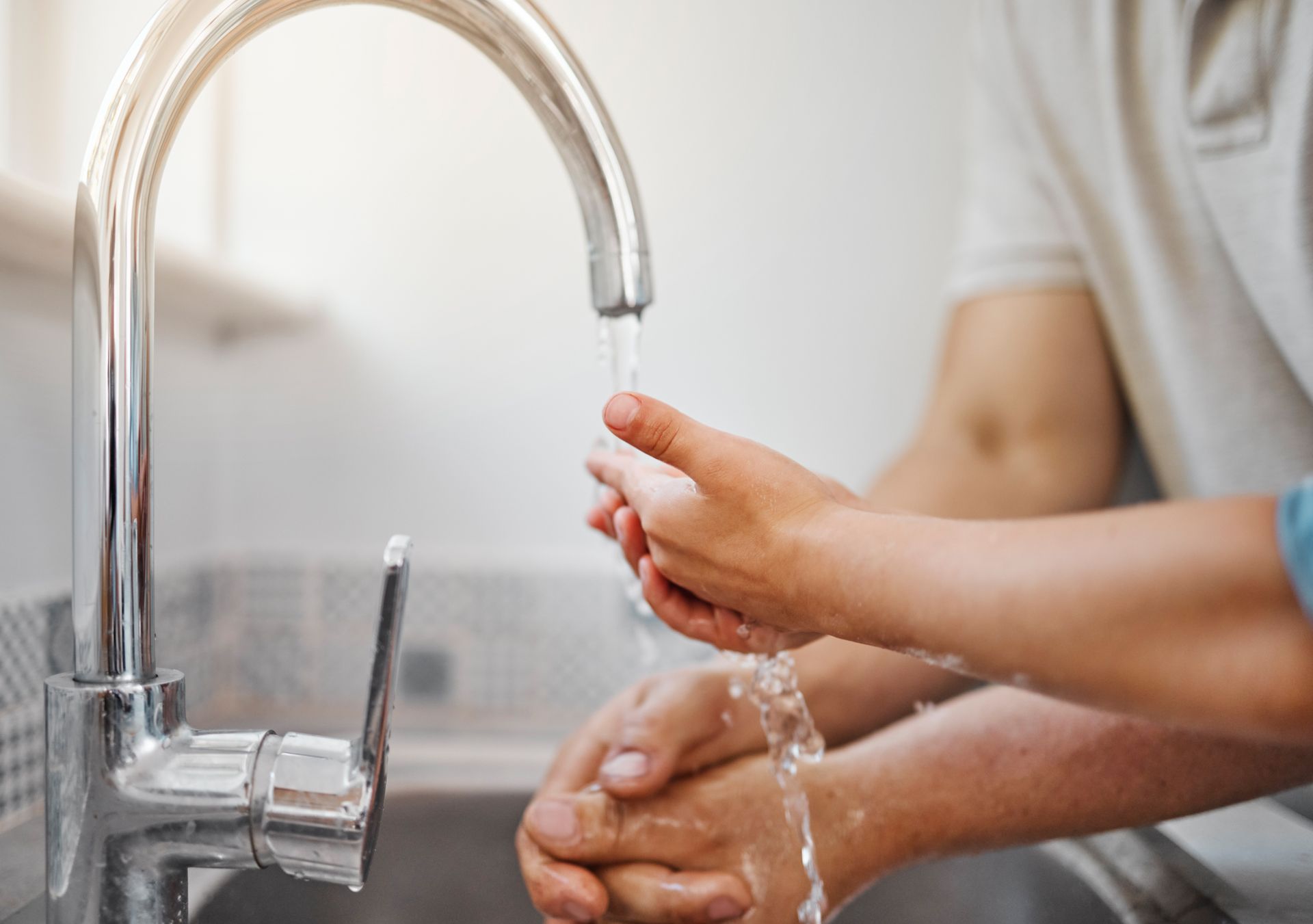 Father and son washing hands at a tap