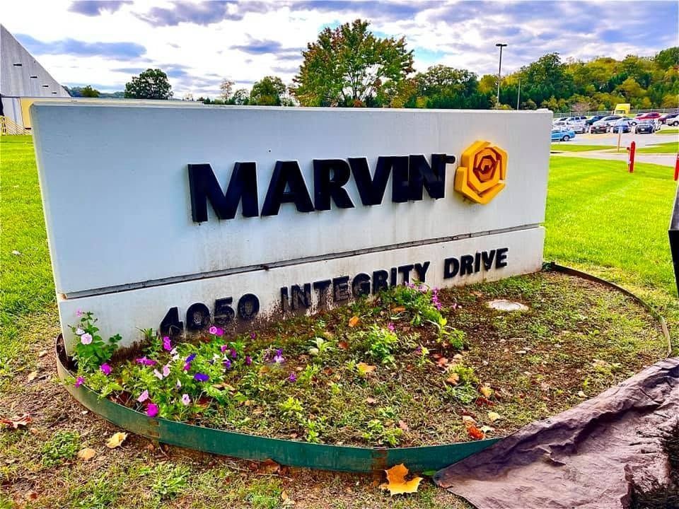 Marvin company sign at 4050 Integrity Drive beside flowers and a grassy roadside
