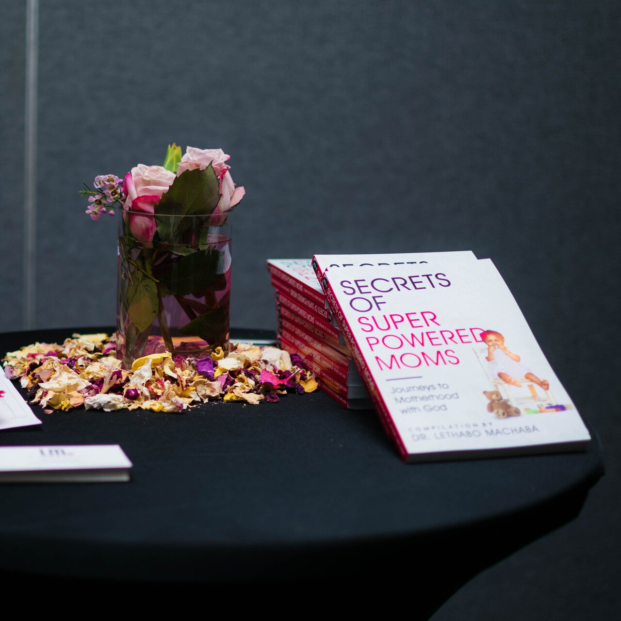 numerous copies of a book neatly piled on a table