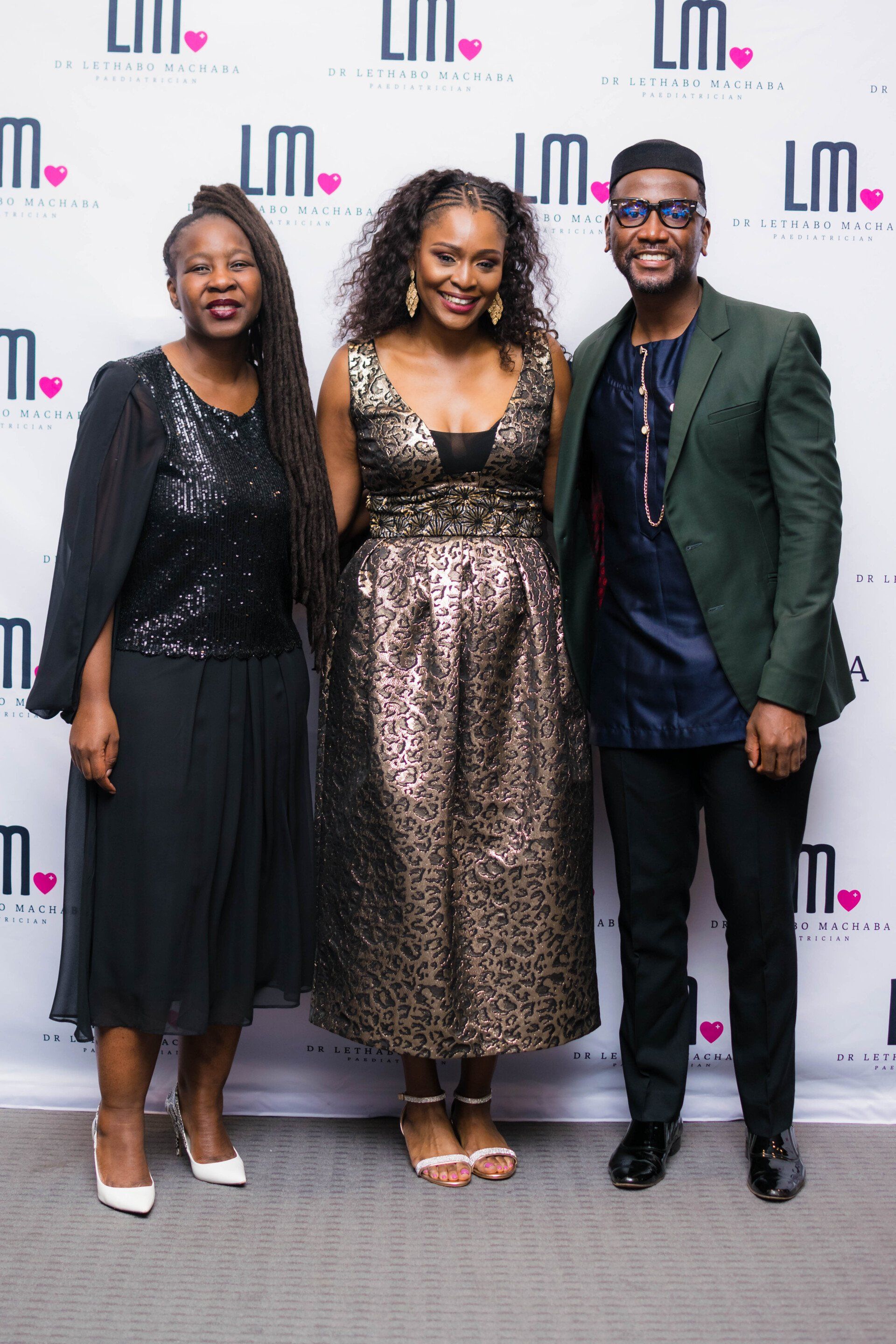 three professional people posing for a photo at an evening event