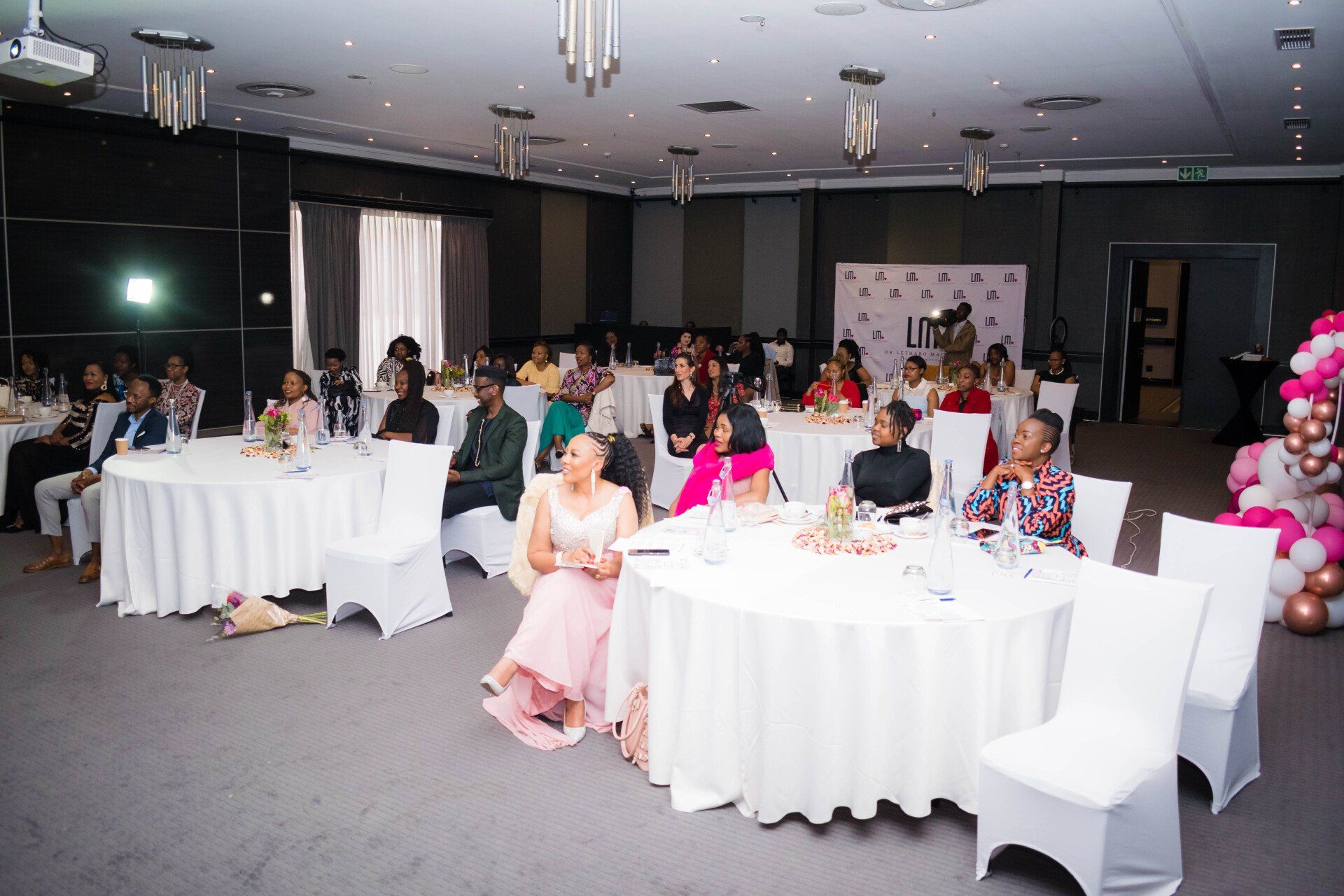 woman seated at decorated tables at an indoor events