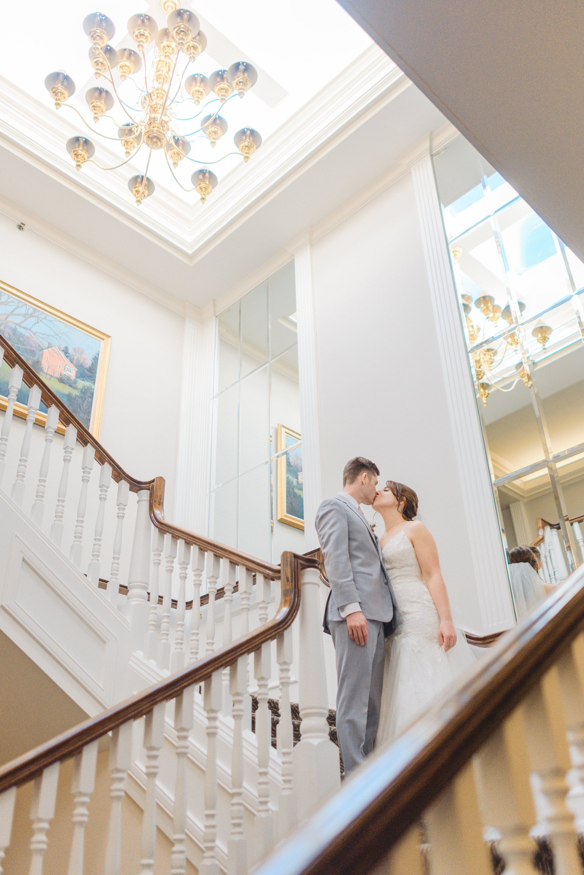 Wedding Couple standing on grand staircase kissing in Pennsylvania