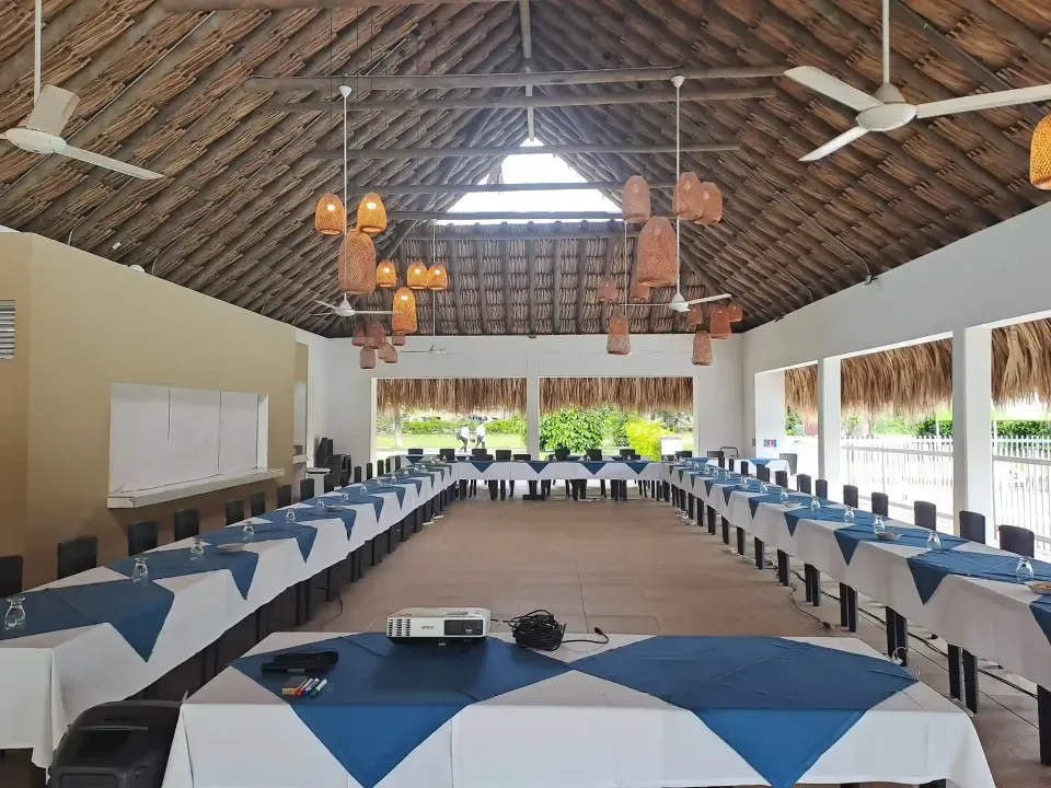 Montaje tipo U en salón de eventos en Villeta, con mesas y sillas, espacio campestre para reuniones y banquetes.