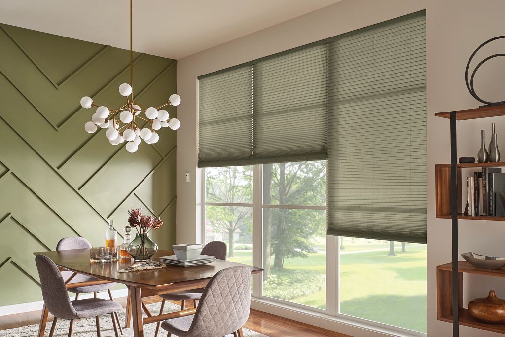 Green cellular shades covering tall windows in a modern dining room