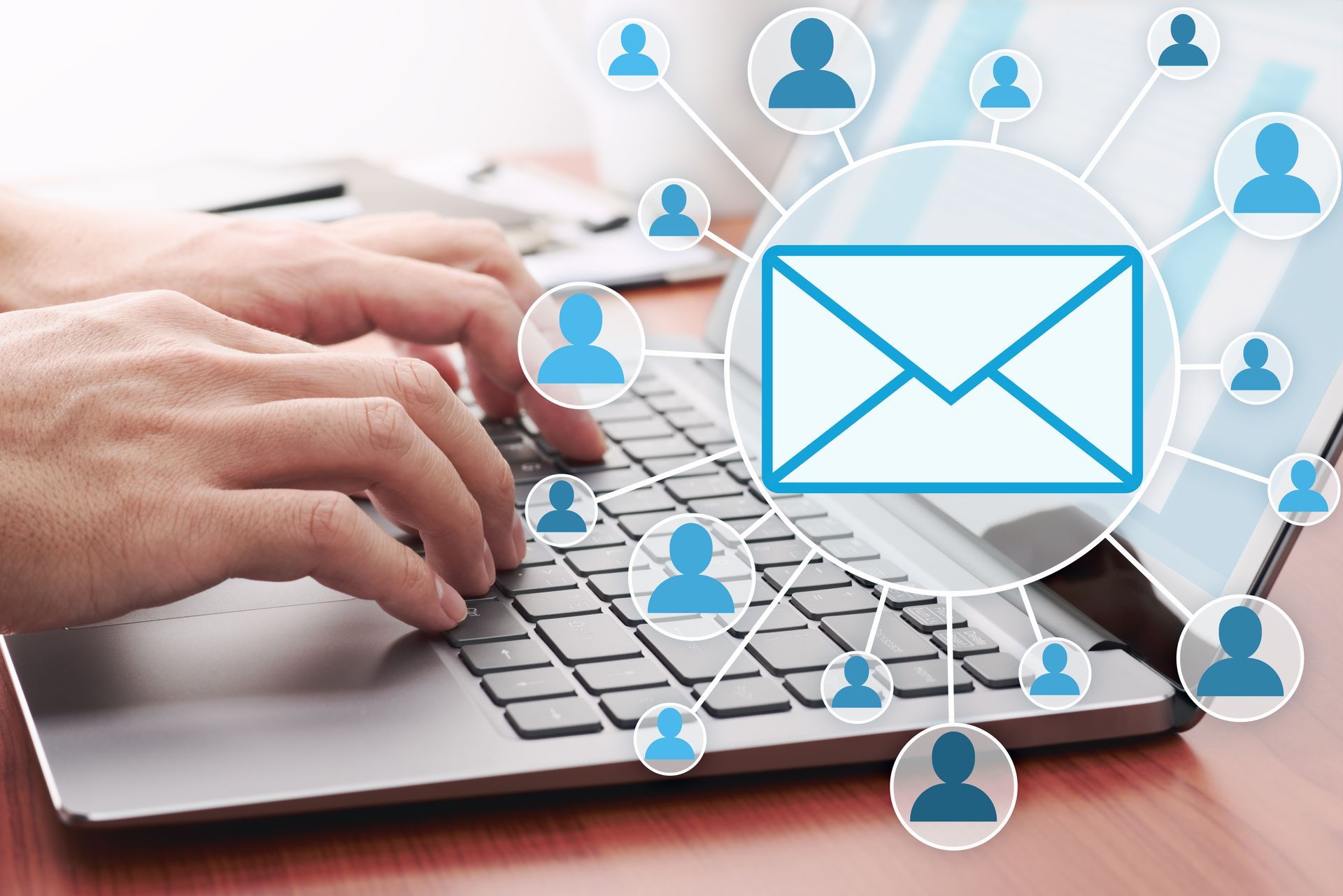 A person is typing on a laptop computer with a picture of an envelope on the screen.