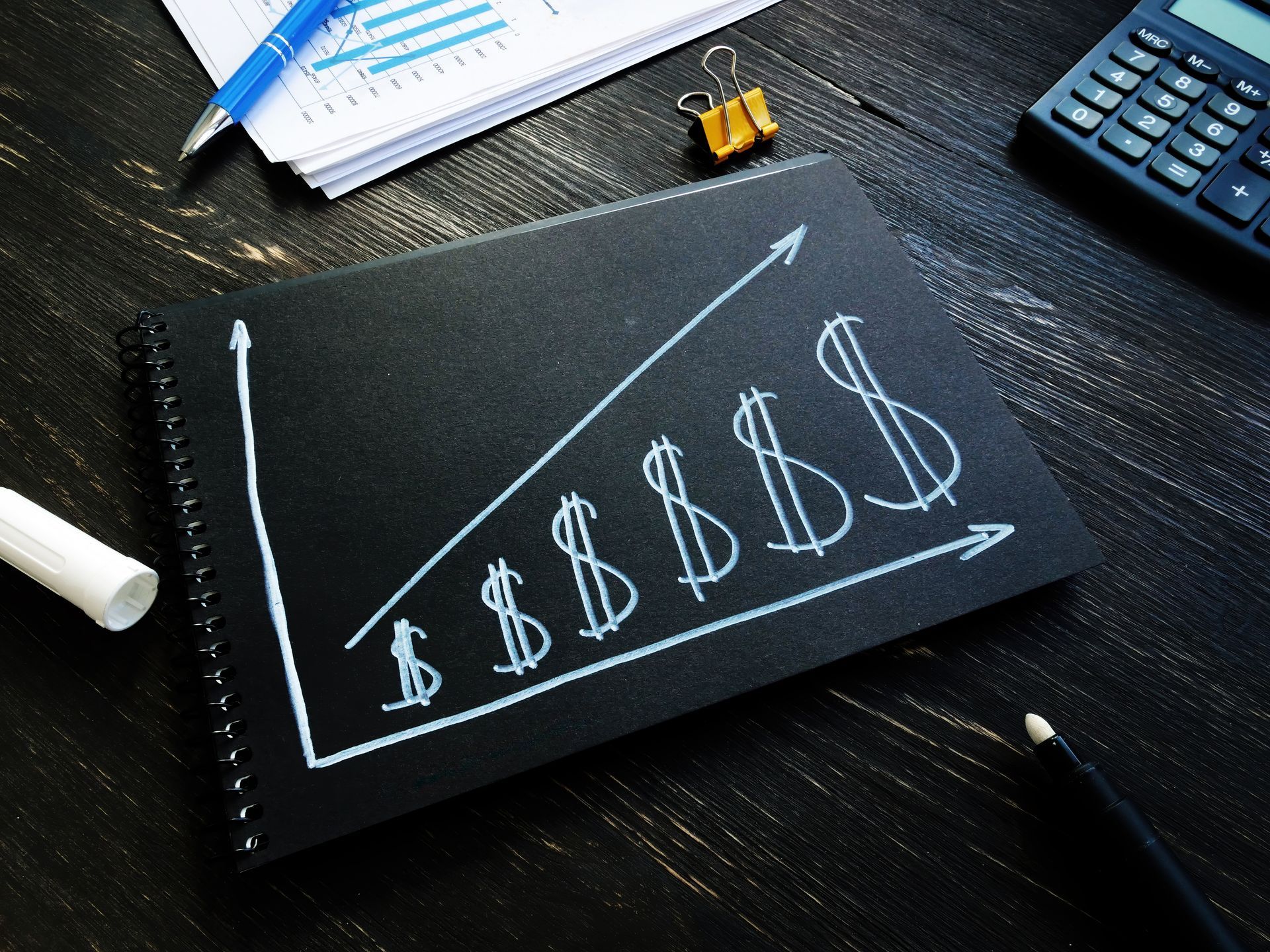 A chalkboard with a graph showing a rising dollar sign