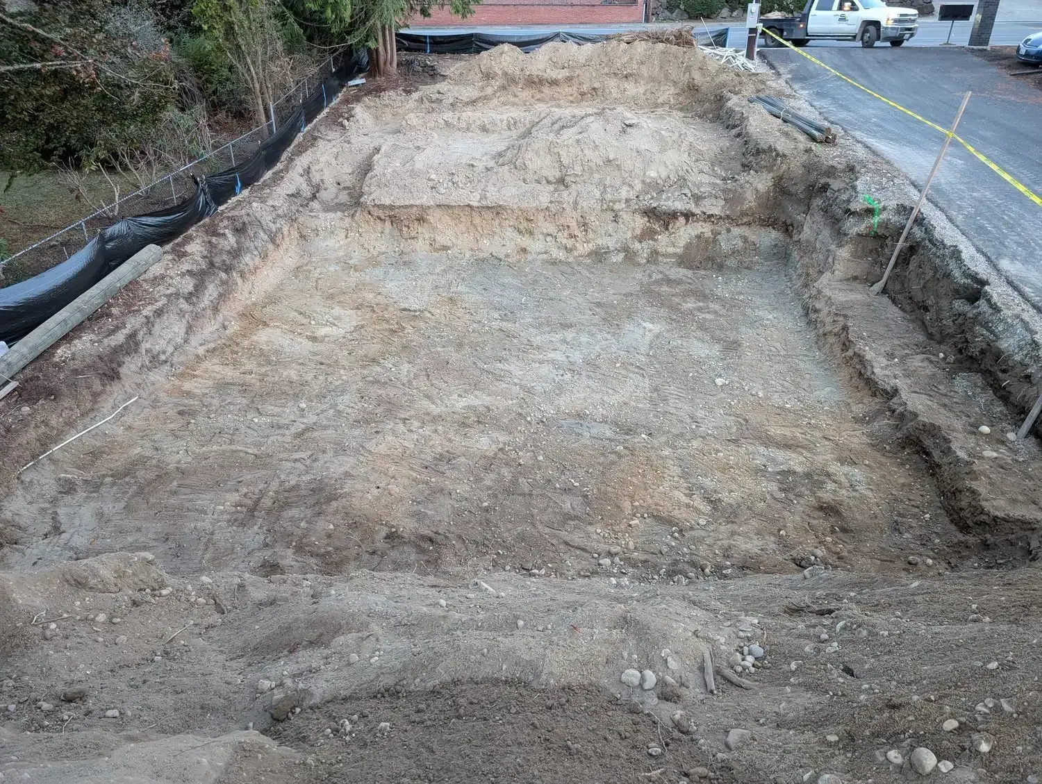 A large pile of dirt is sitting on the side of a road.
