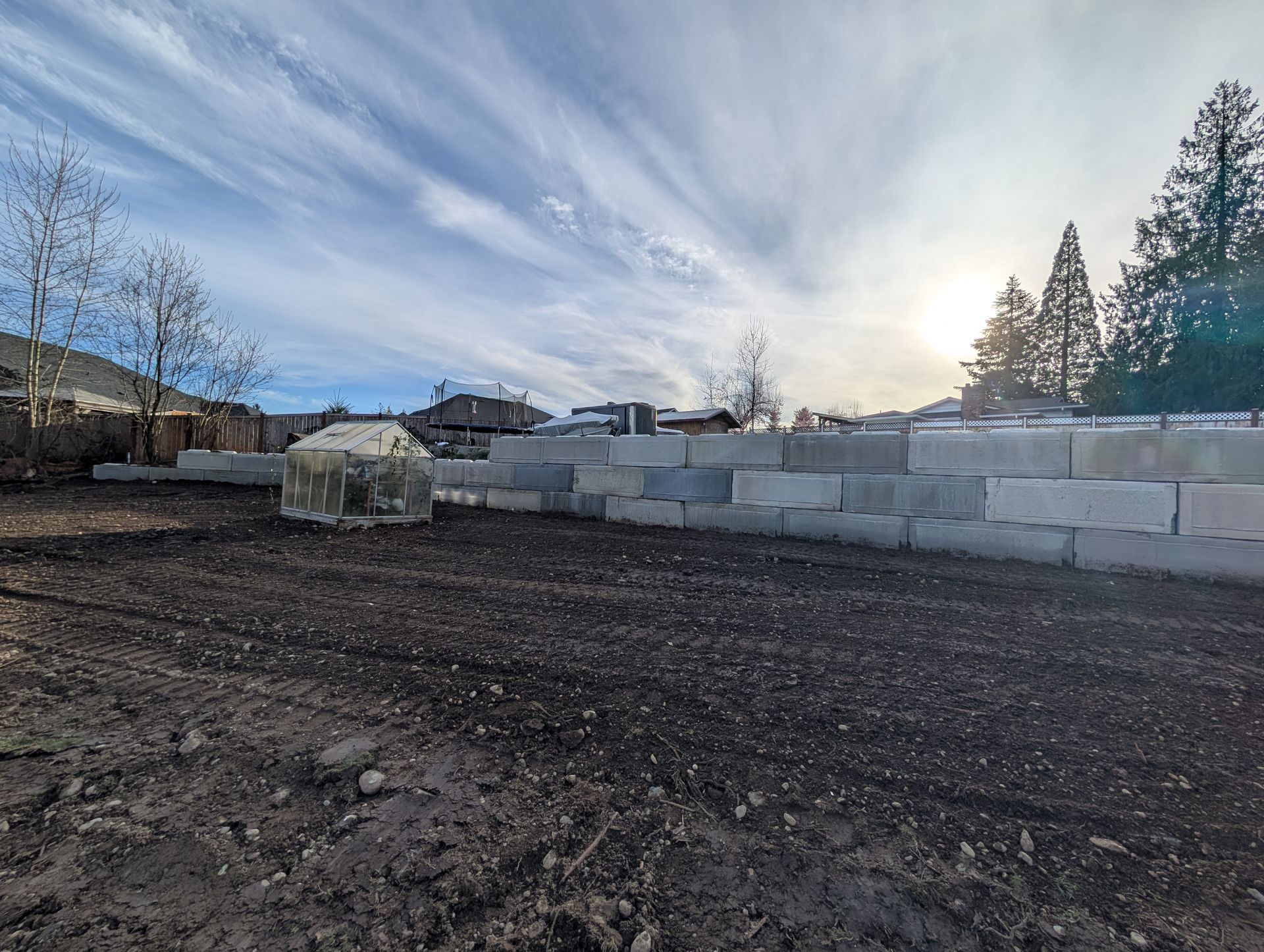 A large concrete wall is being built in a dirt field.