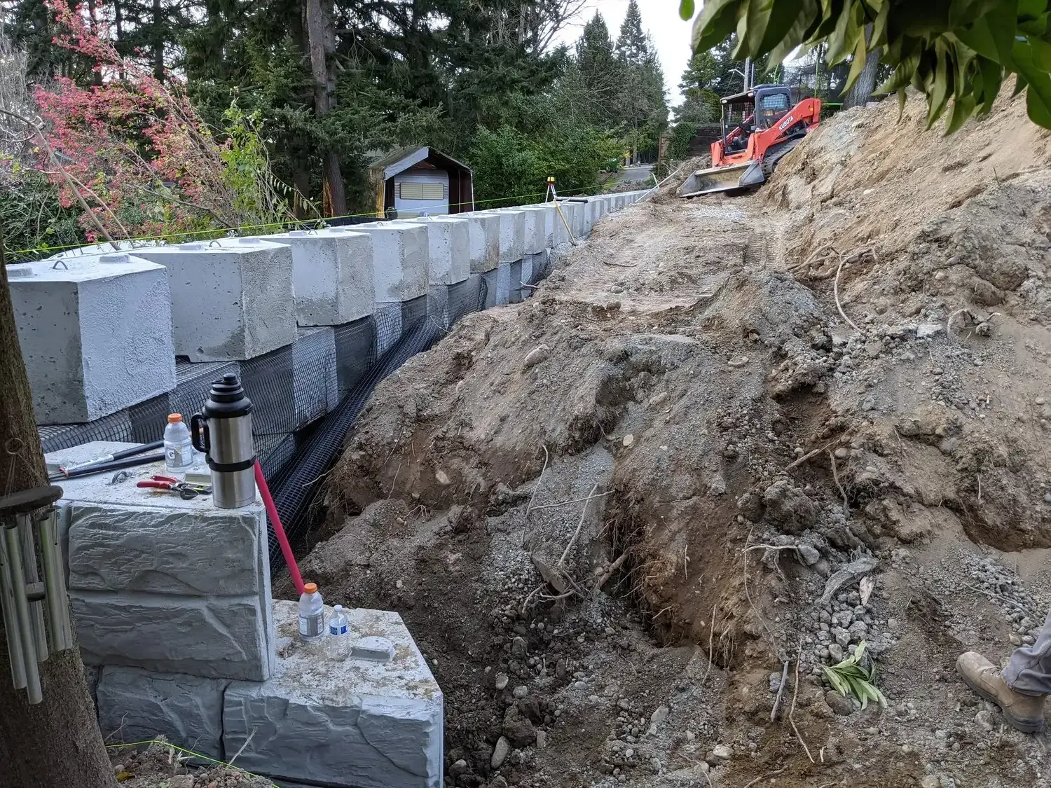 A brick wall is being built on top of a dirt hill.