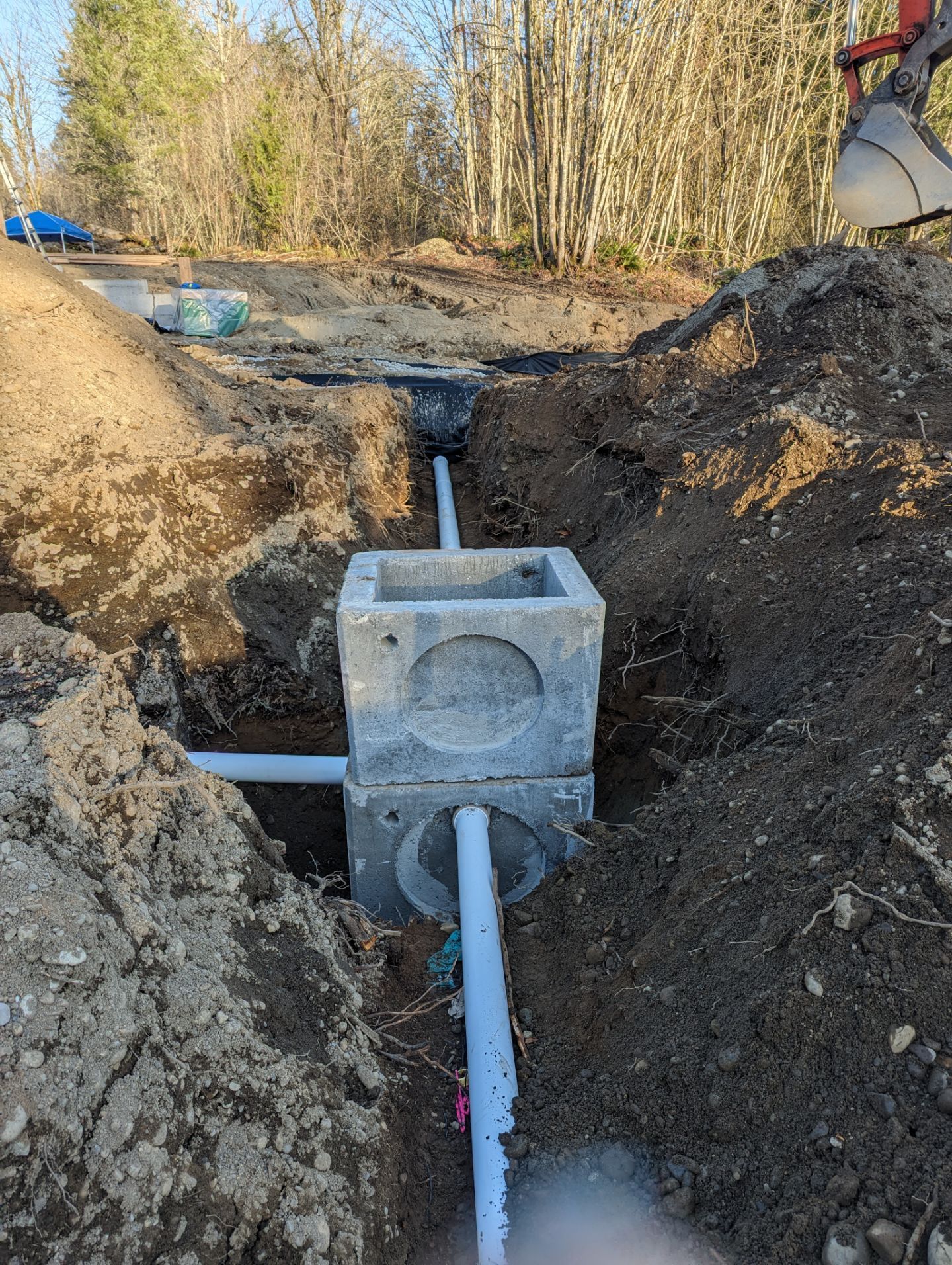 A pipe is being installed in a hole in the ground.