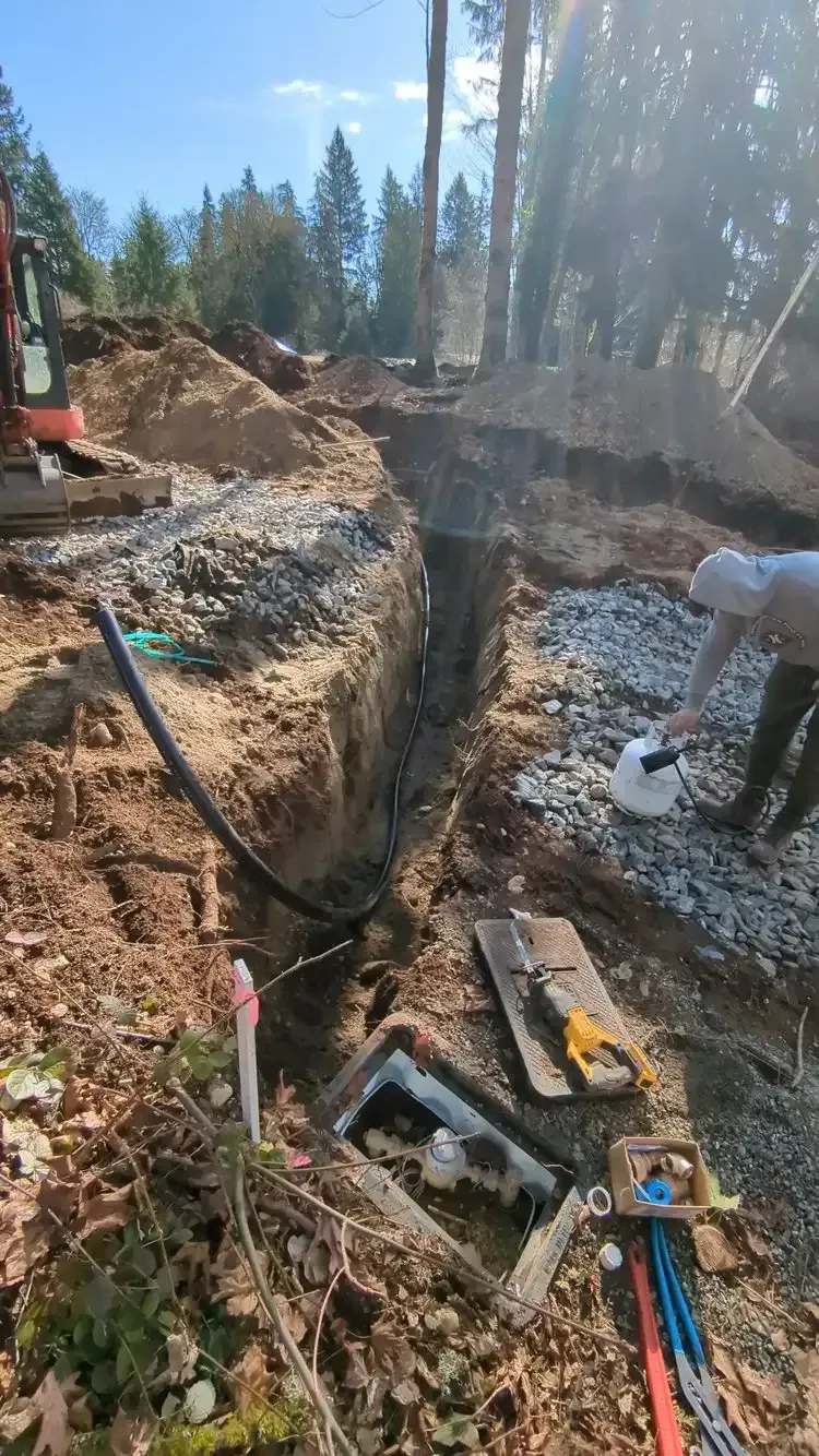 A man is digging a hole in the ground in the woods.