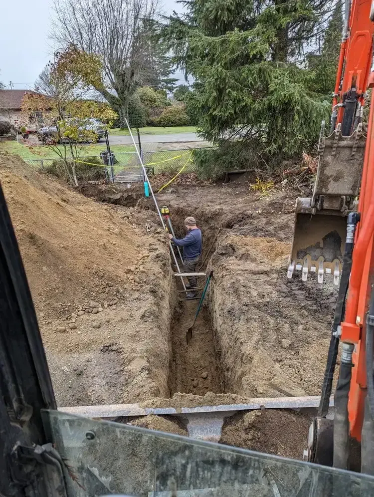A man is digging a hole in the ground with a shovel.