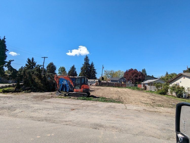 A large excavator is parked in the middle of a dirt field.