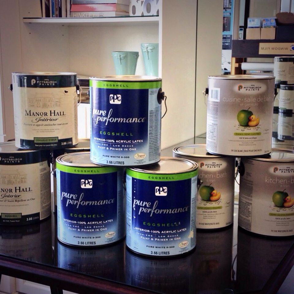 Several cans of pure performance paint sit on a table