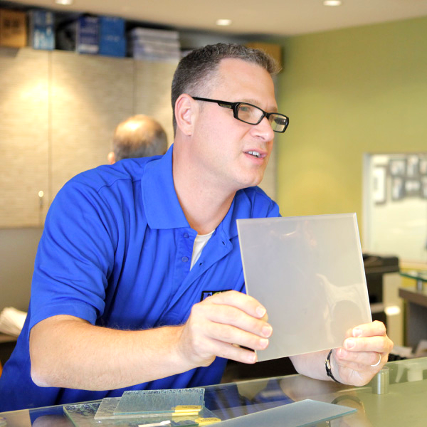 A man in a blue shirt is holding a piece of paper