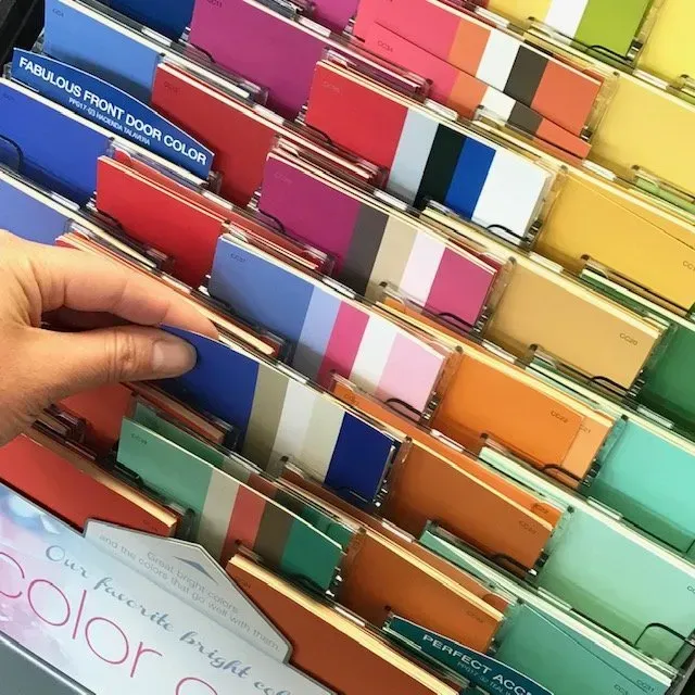 A hand is reaching for a color card that says fabulous front door color