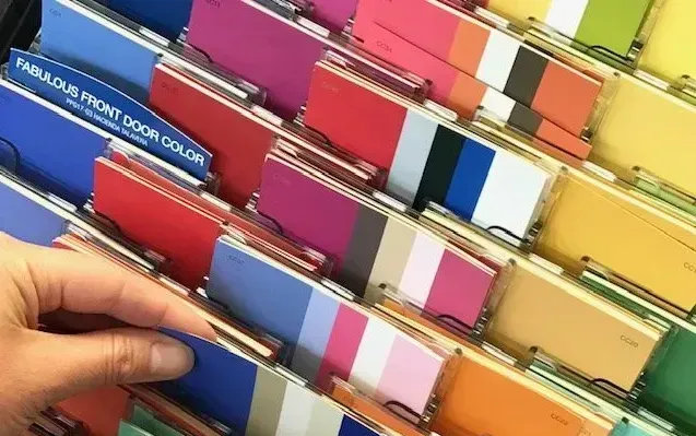 A hand is reaching for a color card that says fabulous front door color