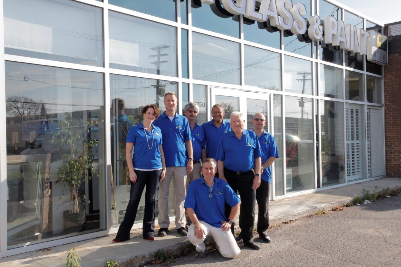 A group of people posing in front of a glass building