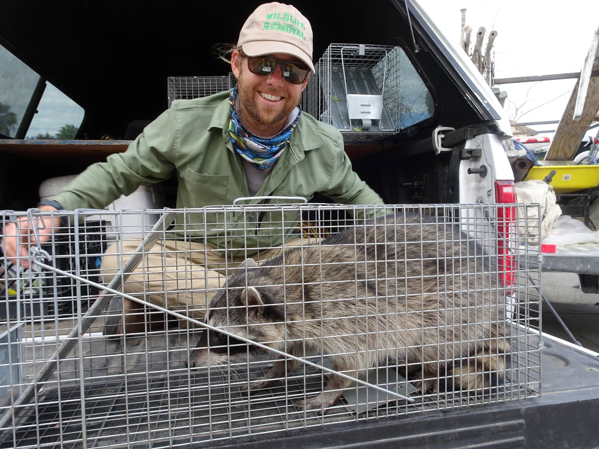 A Person Smiling And Holding A Cage Of A Animal — Jacksonville, FL — CritterPro Inc.