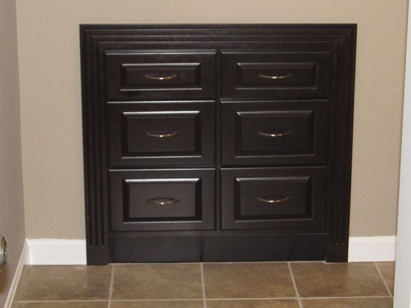 Dark double-door cabinet with six drawers in a beige room above tiled floor