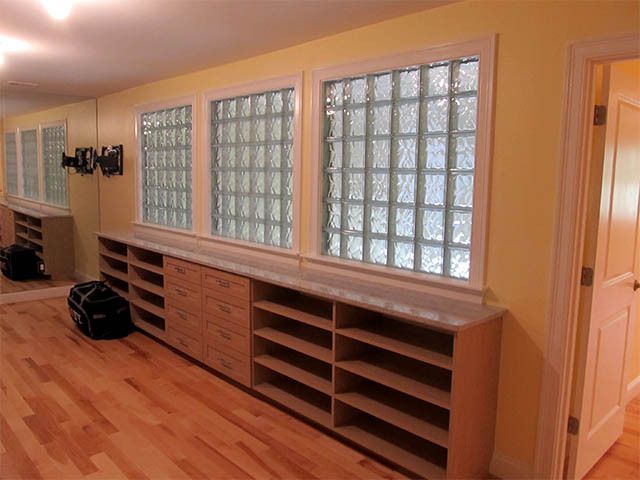 Bright hallway with glass block windows and built-in wooden cabinets along the wall