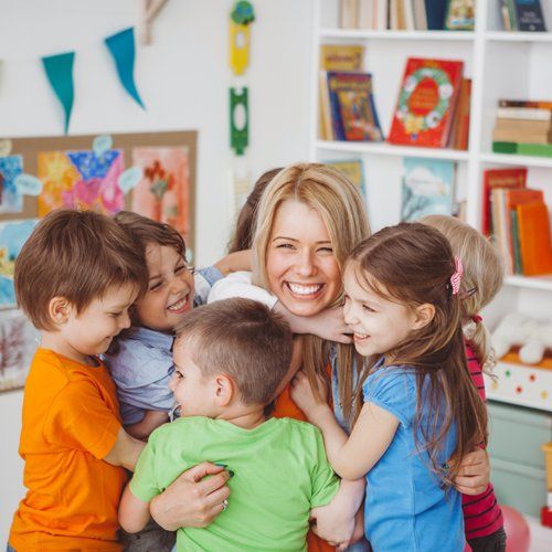 Kids Hugging Their Teacher — Kankakee, IL — Lasting Impressions Learning Centers Kids Hugging Their Teacher — Kankakee, IL — Lasting Impressions Learning Centers