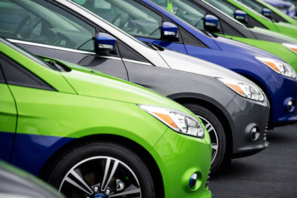 Several colorful cars parked in a row, including yellow, gray, and blue vehicles.