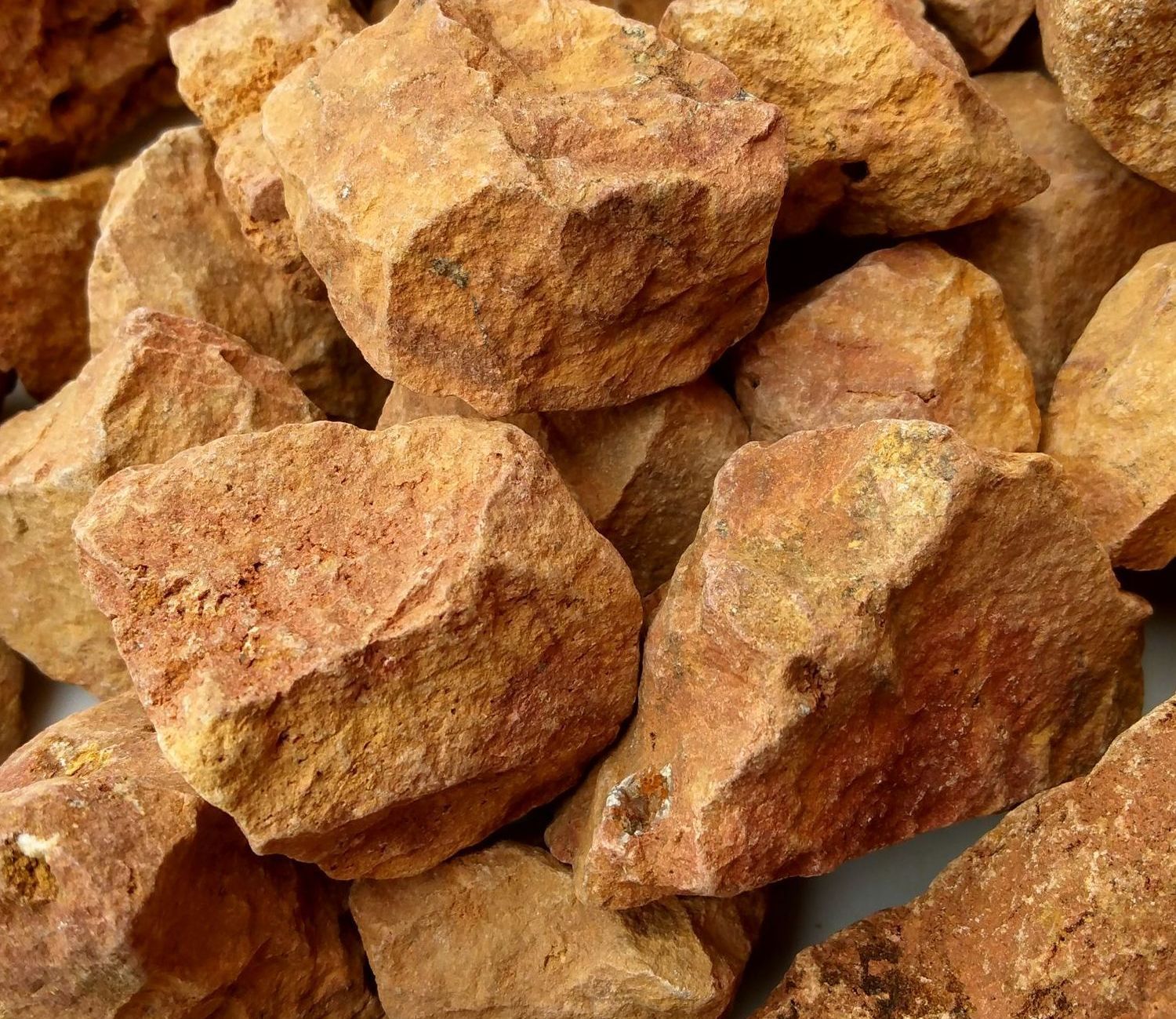 A pile of brown rocks on a white surface.