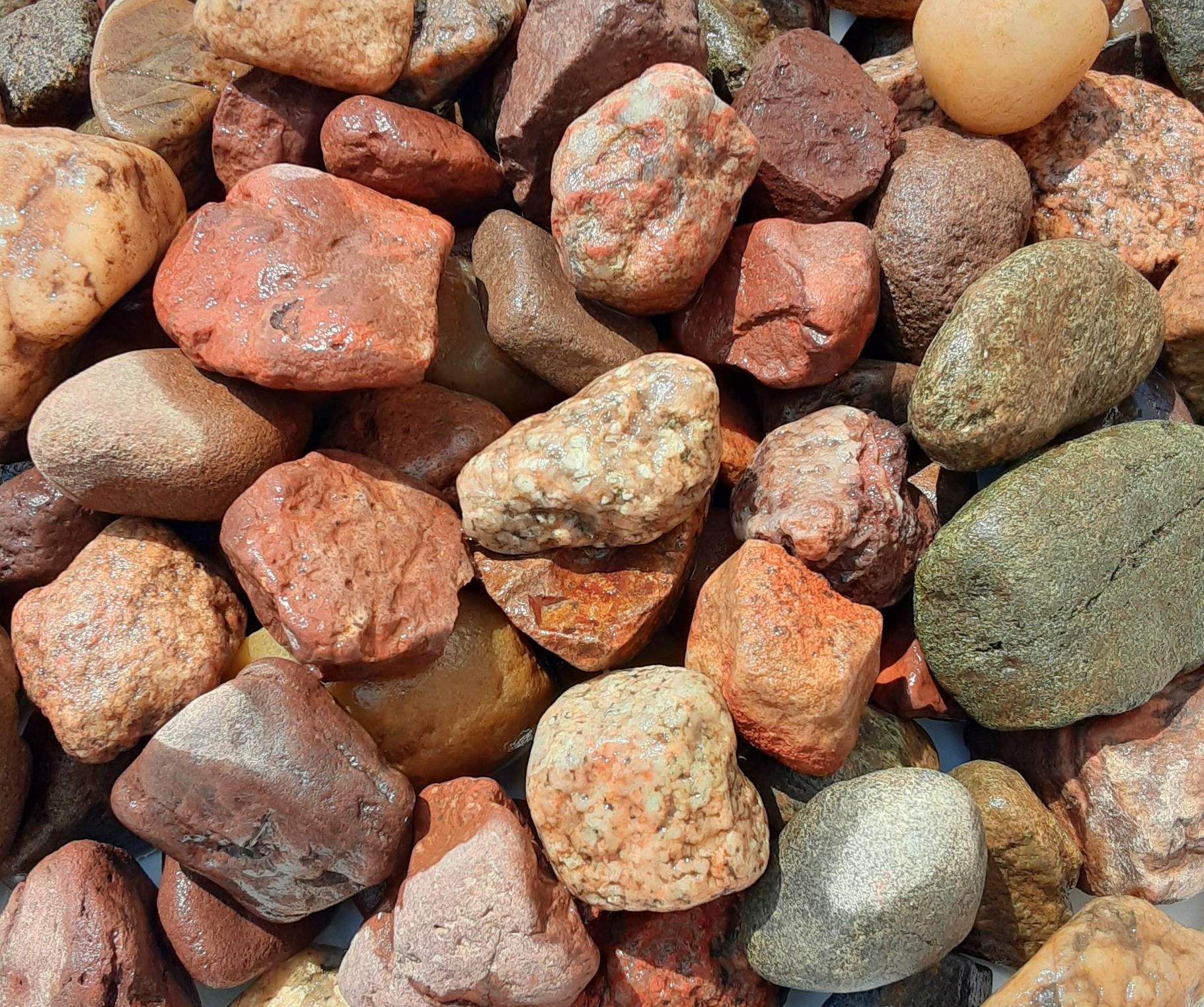 A white plate topped with a pile of rocks of different colors