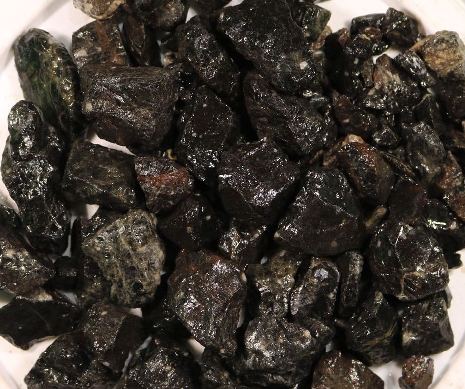 A pile of black rocks on a white surface
