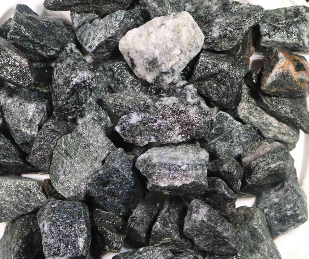 A pile of black rocks on a white surface.
