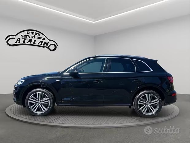 Vista laterale di un SUV blu scuro in uno showroom con il logo Catalano Auto sulla parete.