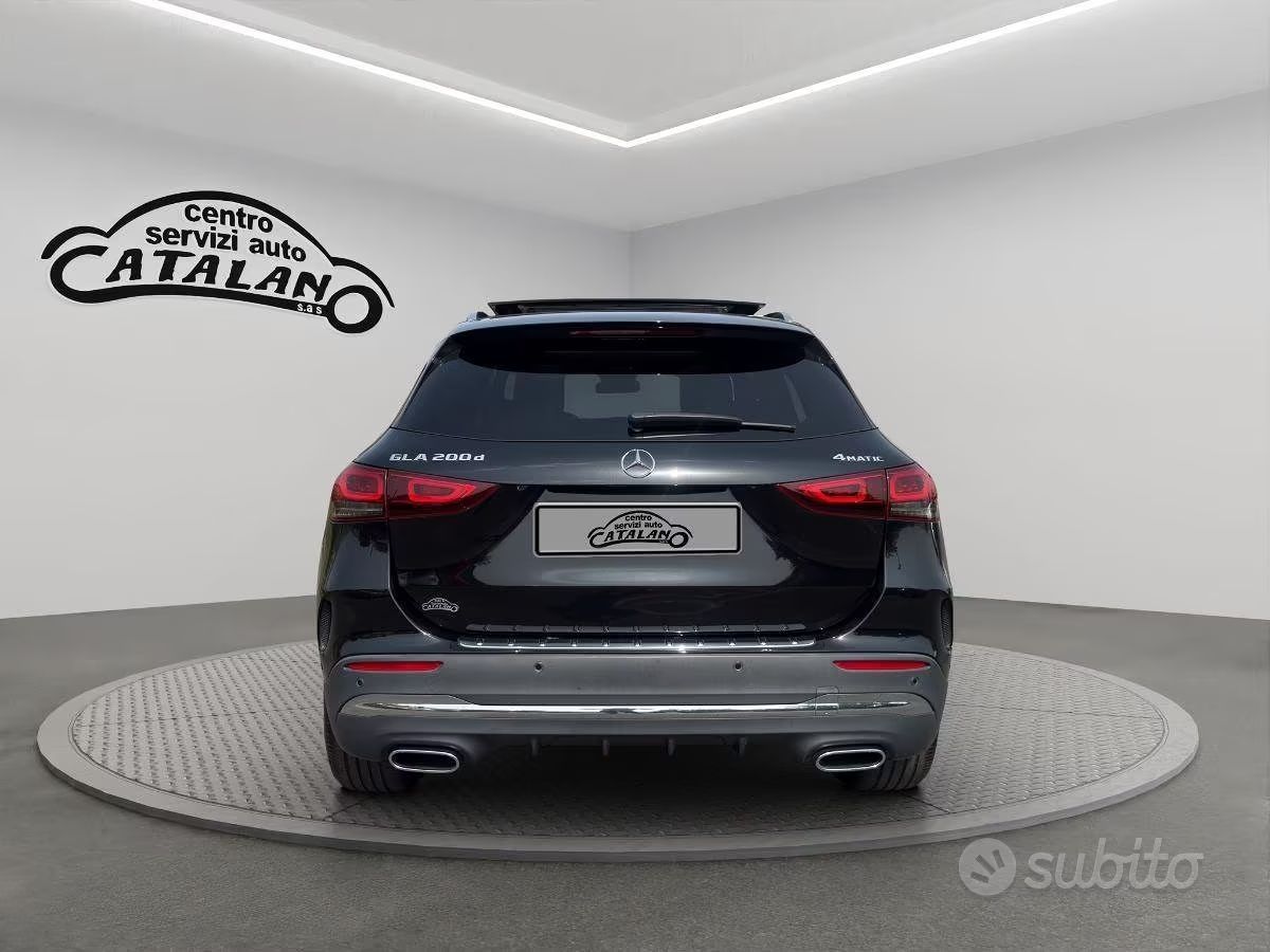 Vista posteriore di un SUV nero su una piattaforma espositiva girevole in uno showroom.