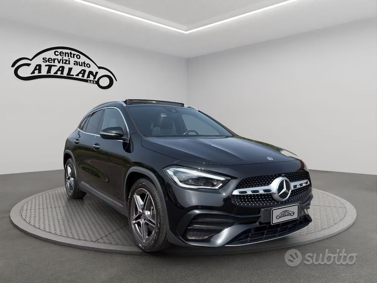 Un SUV Mercedes-Benz nero su un espositore girevole in uno showroom, con il logo della concessionaria sulla parete.