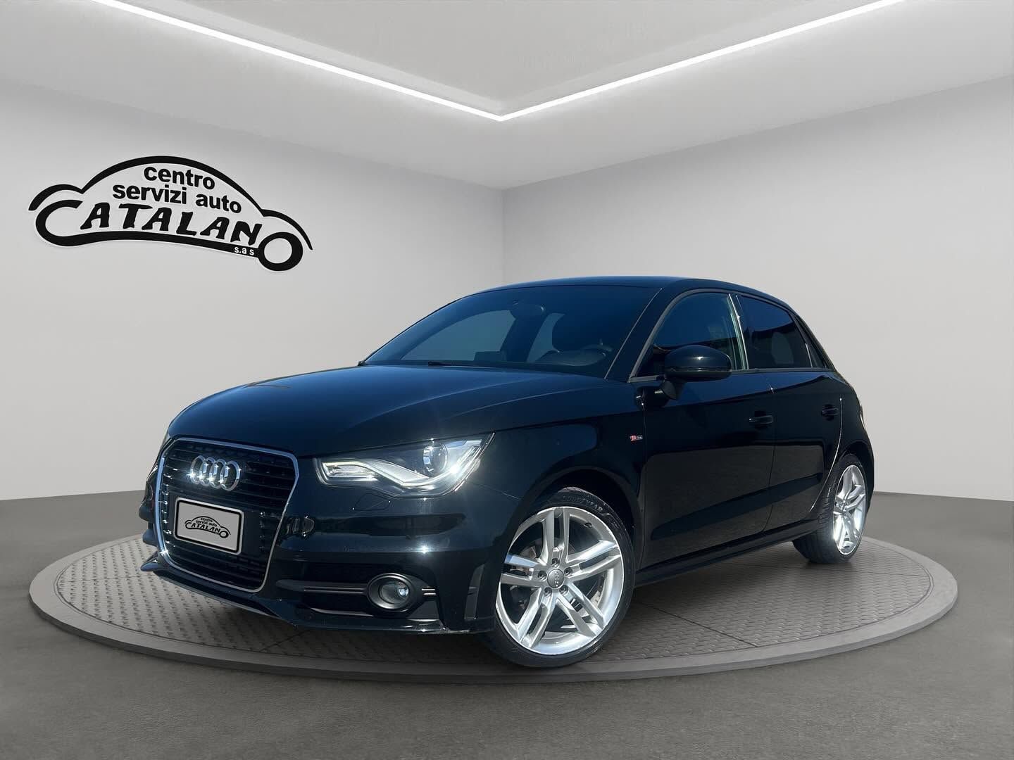 Berlina Audi nera su una piattaforma girevole da esposizione in uno studio luminoso