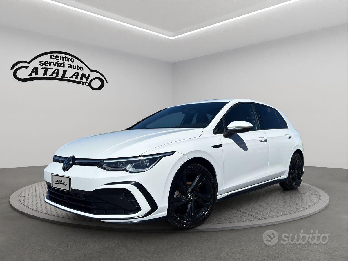 Auto hatchback bianca con cerchi neri esposta in uno showroom, vista frontale angolata