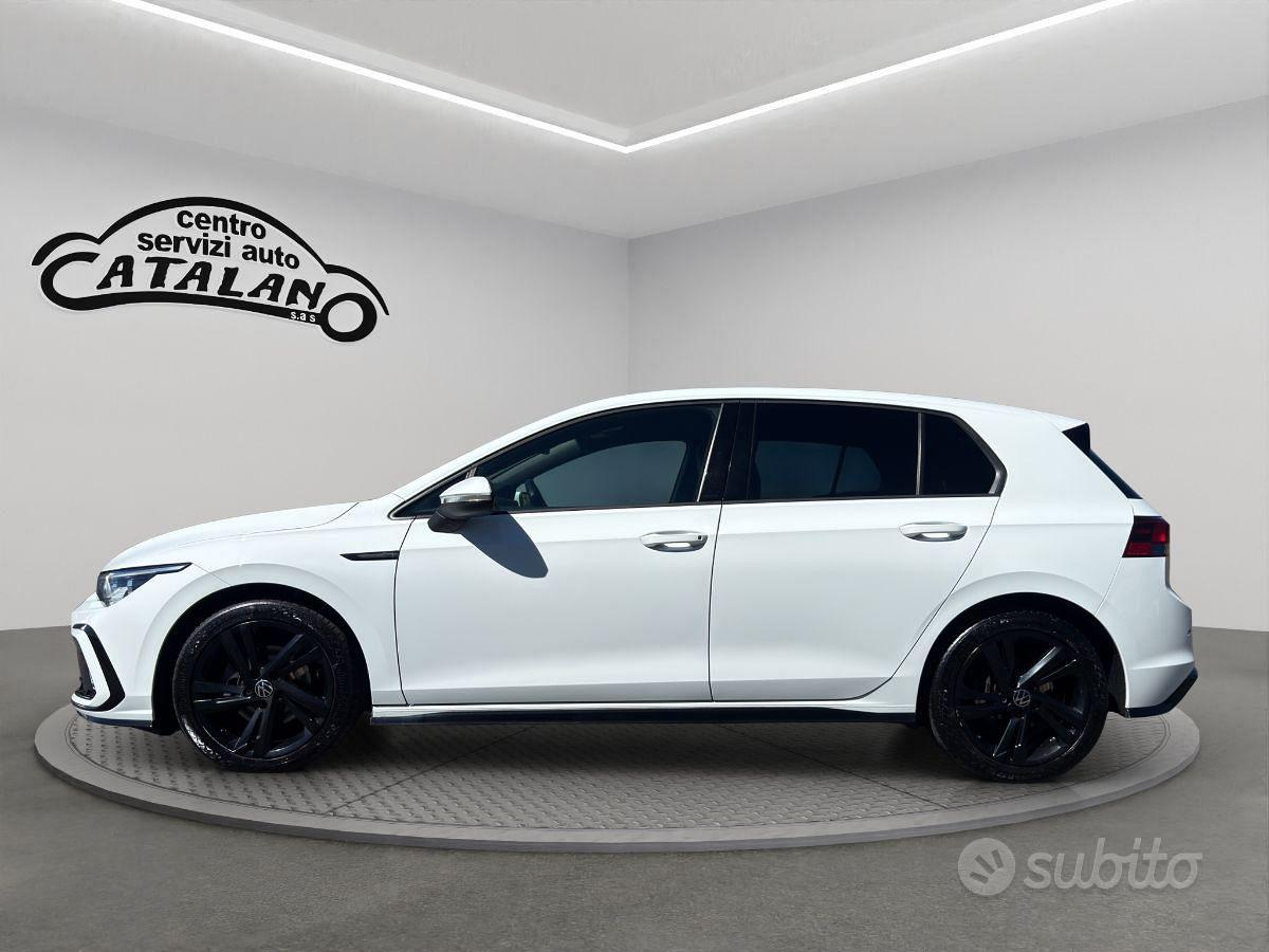 Auto hatchback bianca con cerchi neri esposta in uno showroom con il logo CATALANO a parete.