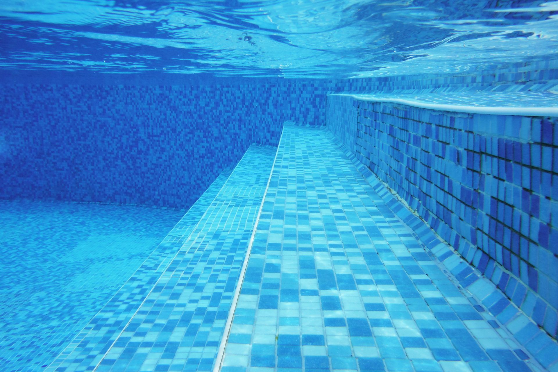 Underwater shot of blue stairs and tiles on a pool bottom. Underwater shot of blue stairs and tiles on a pool bottom.