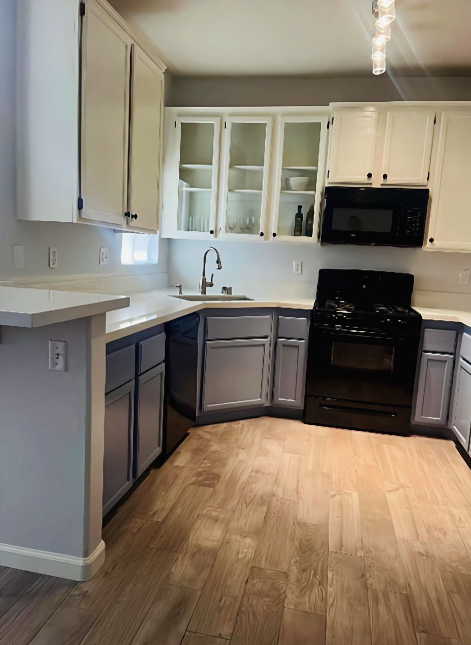 A kitchen with a brick wall and a wooden floor.