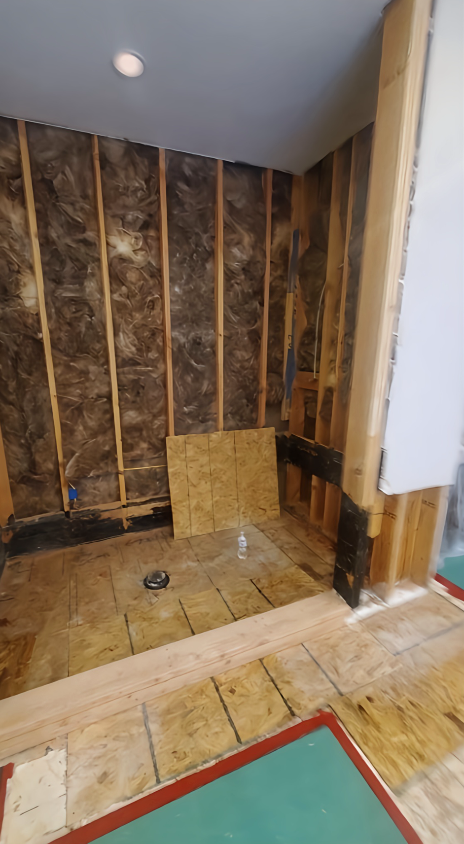 A blue fan is sitting on a wooden floor in a room.