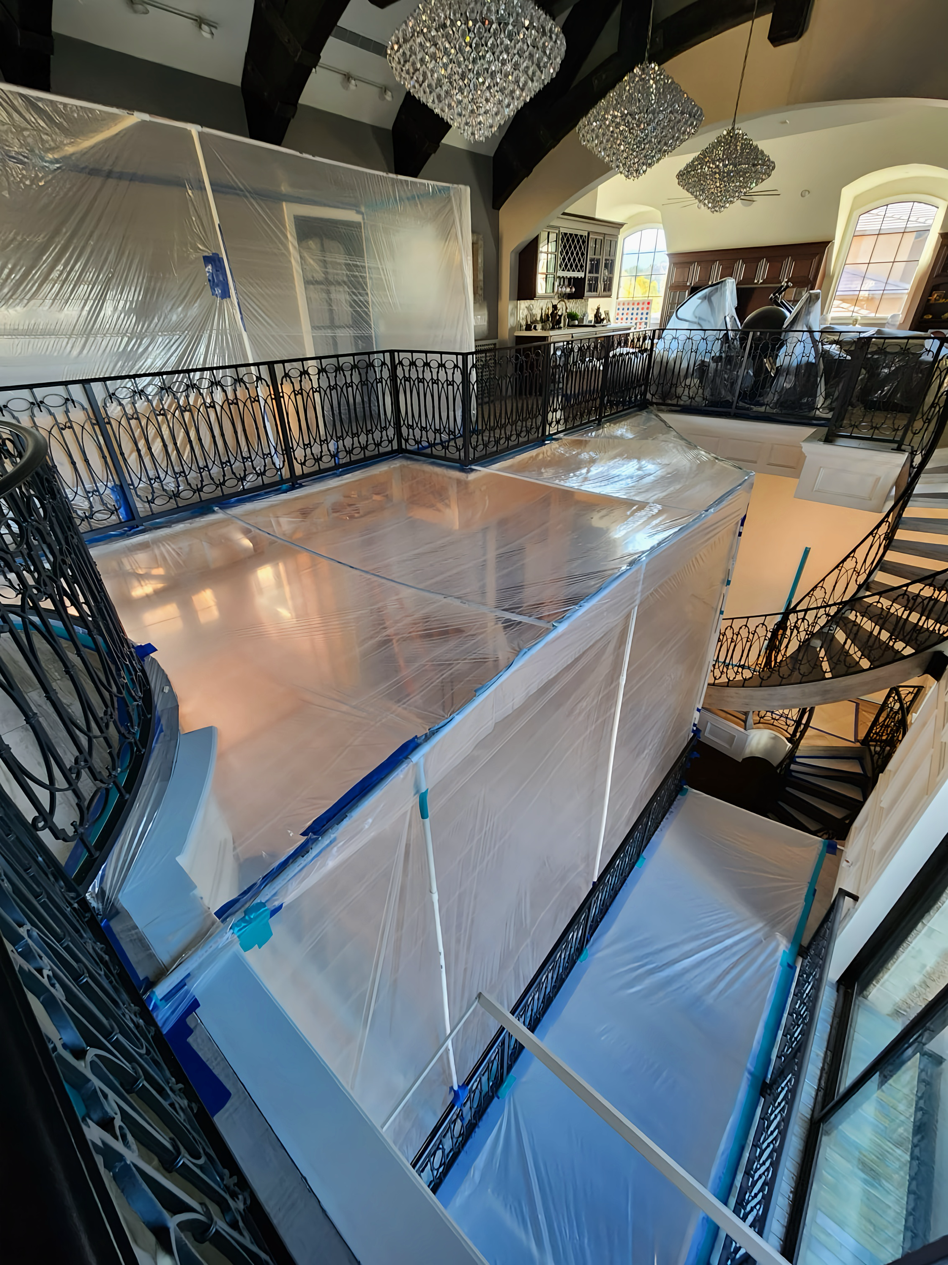 Interior with plastic sheeting covering a balcony during renovation, seen from above.