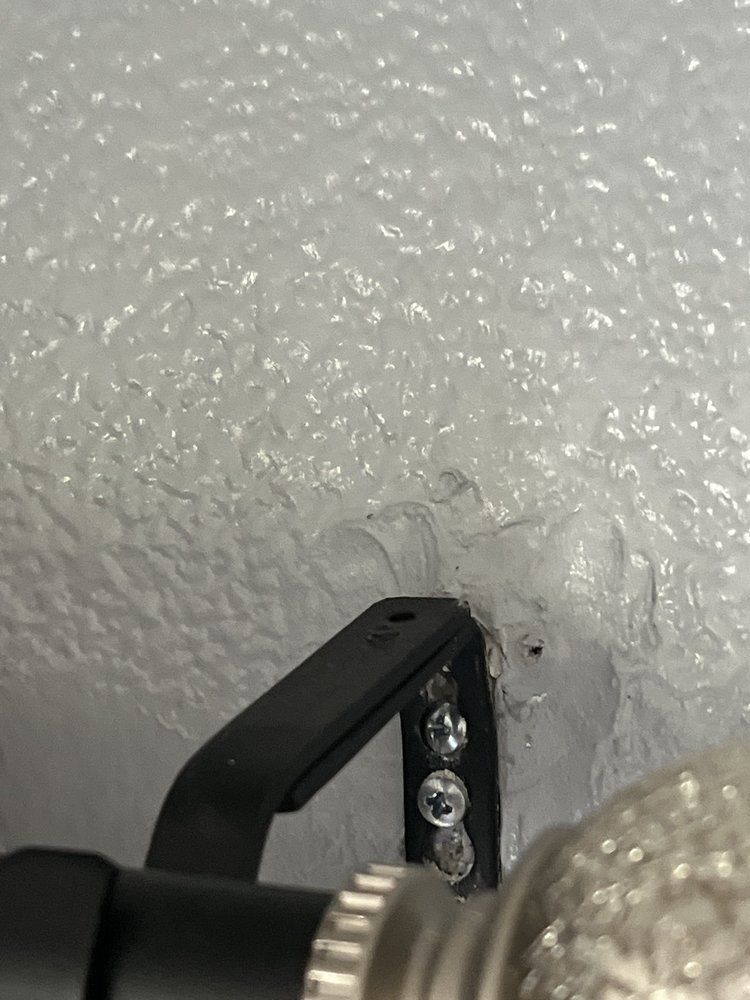 A close up of a microphone sitting on a white wall.