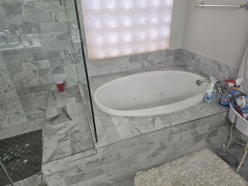 A bathroom with a jacuzzi tub and a walk in shower.
