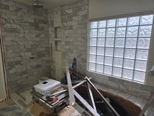 A bathroom under construction with a brick wall and a window.