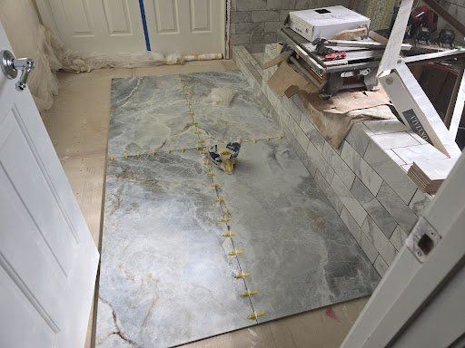 A large tile is being installed in a bathroom.
