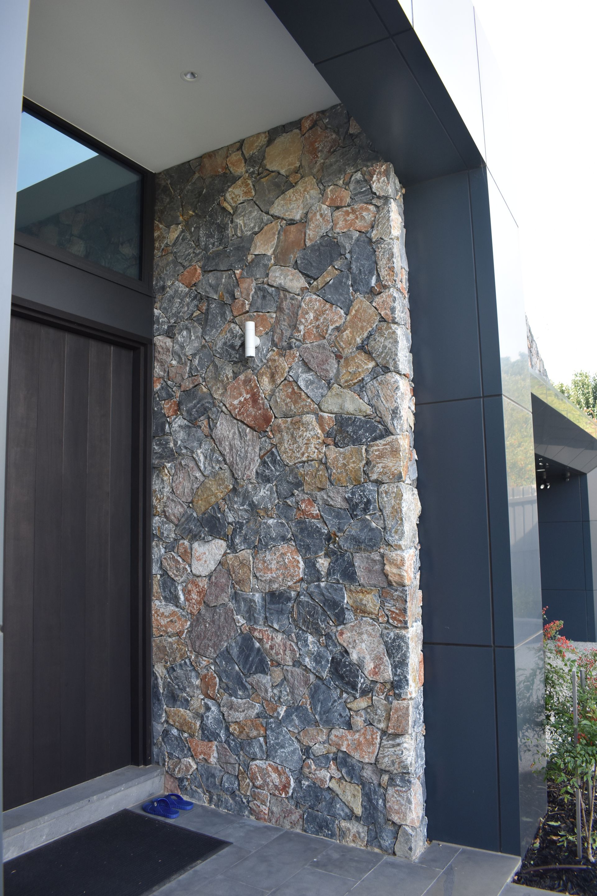 Stone-clad front entry with dark trim and a covered porch.
