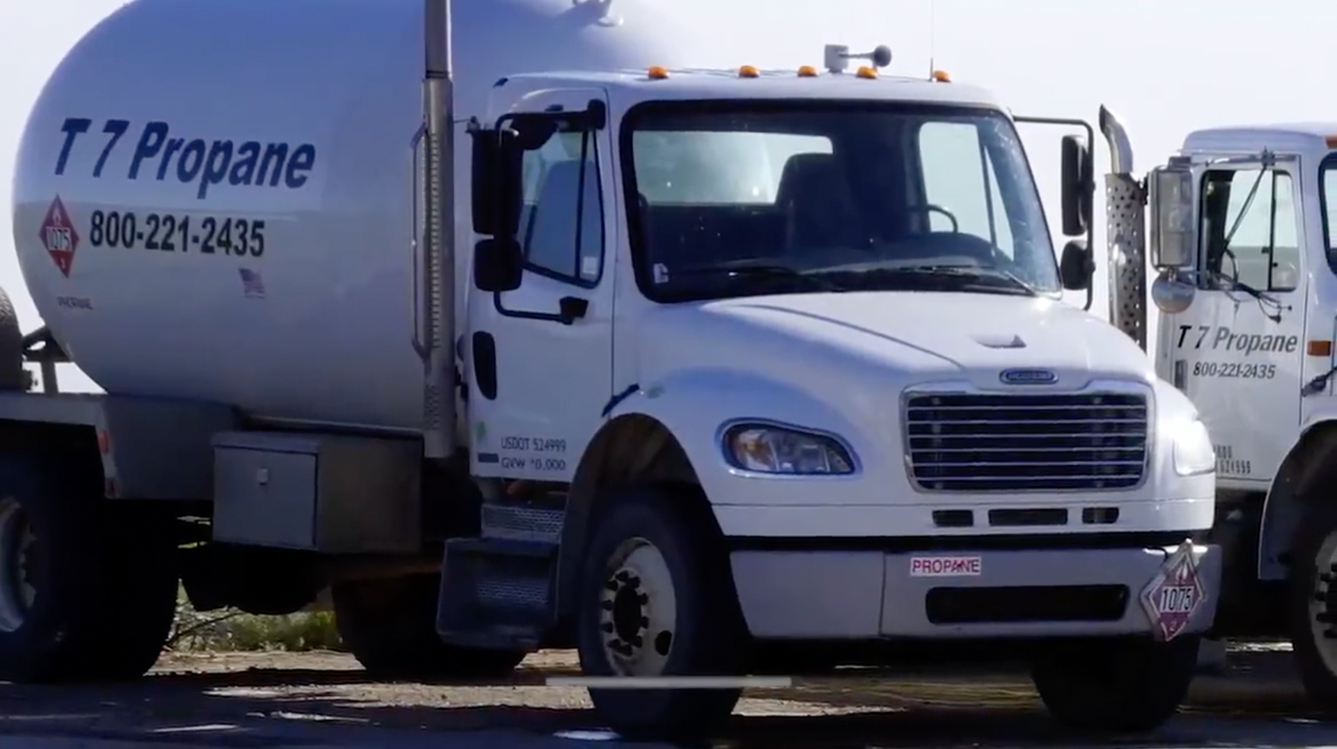 a t7 propane truck is parked next to another truck