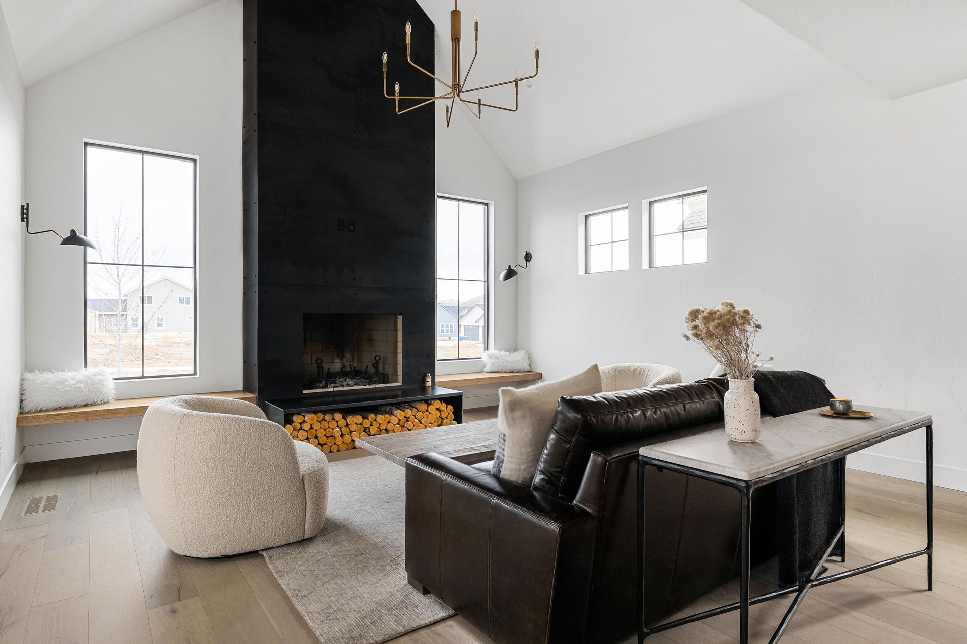 A living room with a couch , chairs , table and fireplace.